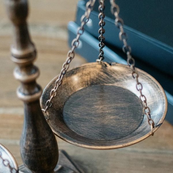 From above of judicial symbols consisting of Scales of Justice and small judge hammer with curly handle